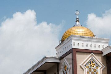 A stunning view of a gold mosque dome with a cloudy blue sky background, symbolizing peace, faith, and architectural beauty. Ideal for use in travel blogs, ramadan, or promotional 