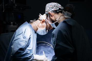 A team of professional surgeons performs surgery in a modern hospital. Concept skills working using...