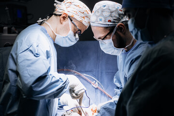 A team of professional surgeons performs surgery in a modern hospital. Concept skills working using...