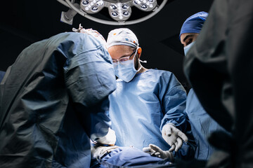 A team of professional surgeons performs surgery in a modern hospital. Concept skills working using...