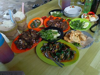 Closeup Grilled fresh seafood: shrimp, fish, octopus, green mussels, fresh green food and vegetables. Semarang-Indonesia