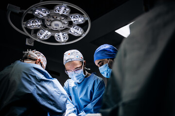 A team of professional surgeons performs surgery in a modern hospital. Concept skills working using...