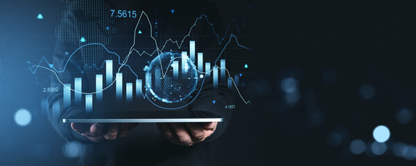 Financial data visualization with bar and line charts displayed above a tablet in a futuristic style on a dark background.