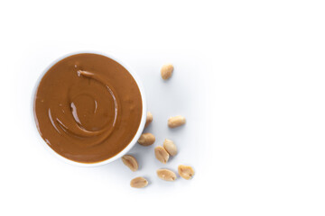 Peanut butter in a bowl isolated on white background. Top view. Copy space