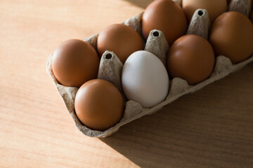 Fresh farm eggs in carton box on wooden table. Eggs in egg boxes