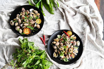 Clams and mussels are artfully arranged with herbs against a green backdrop.