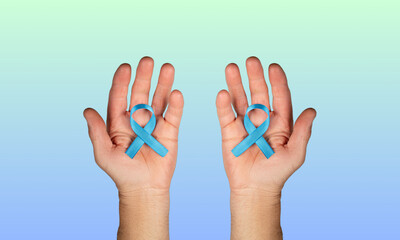 blue satin ribbon holding in kids hands on light background. Liver, kidney cancer awareness, Glaucoma Awareness