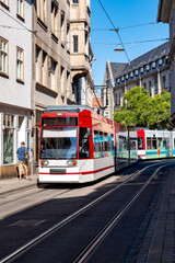 Fototapeta na wymiar A vibrant scene from Erfurt, Thuringia, featuring a modern red and white tram navigating through the city's historic streets