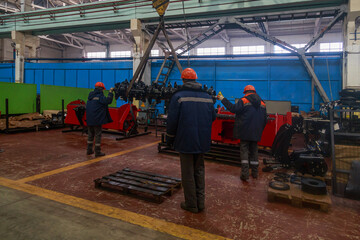 Workers of the plant load a soil processing mechanism.