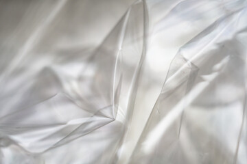 Crumpled clear plastic background, abstract glossy broken surface texture with creases