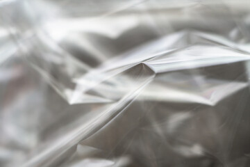 Crumpled clear plastic background, abstract glossy broken surface texture with creases