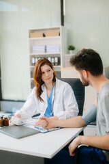 Fototapeta premium Portrait of female doctor explaining diagnosis to her patient. Doctor Meeting With Patient In Exam Room