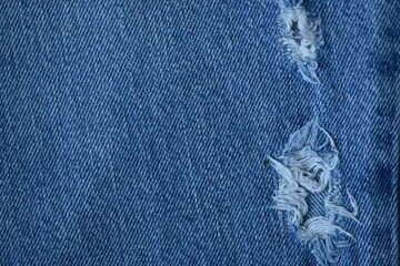 torn light grey denim surface, denim fringe , hole macro texture of blue denim, torn blue denim...