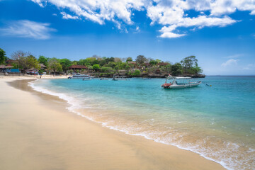 An incredibly tranquil beach scene unfolds, showcasing soft, warm sands, crystalclear turquoise waters, and vibrant, lush greenery beneath a brilliant blue sky, Nusa Lembongan, Bali, Indonesia