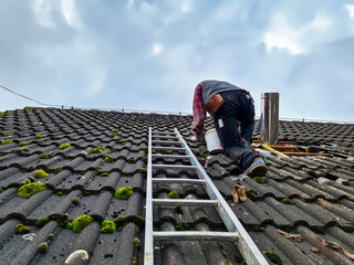 Roofer Installing a Stove Pipe – Working on a Roof with Ladder and Tools.