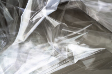 Crumpled clear plastic background, abstract glossy broken surface texture with creases