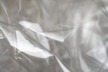 Crumpled clear plastic background, abstract glossy broken surface texture with creases