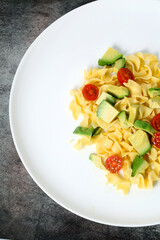 Pasta dish with avocado and tomato