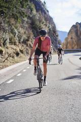 Fototapeta premium Focused woman riding uphill during a road cycling session
