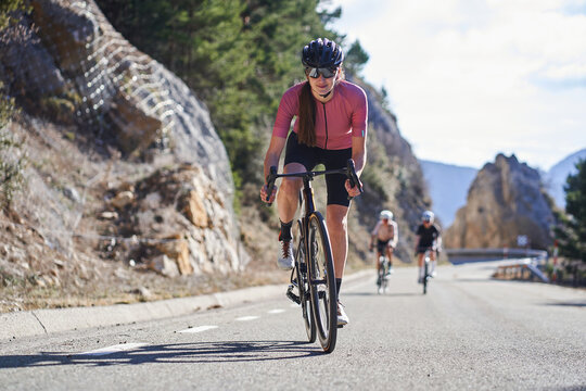 Strong female cyclist climbing a mountain road during a ride