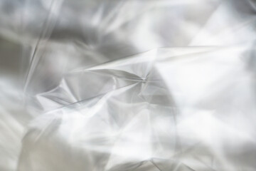 Obraz premium Crumpled clear plastic background, abstract glossy broken surface texture with creases