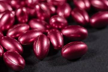 red softgels capsules of vitamins on dark background