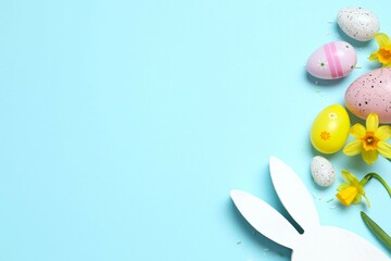 Happy Easter. Colorful eggs, yellow flowers and Easter bunny ears on a pastel color background, space for text or advertising