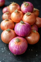 Close-up of fresh red and brown onions on dark background