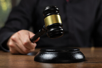 judge's gavel in hand judges is placed on a table in the legal counsel's office