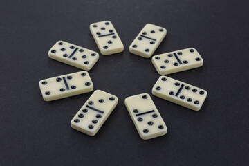 Flat lay composition of chess pieces and dominoes on dark table