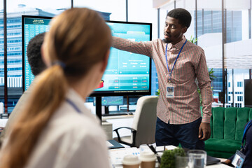 Diverse work team discussing digital marketing trends on interactive board, using analytics to improve sales numbers in a meeting. Business experts developing a startup company.