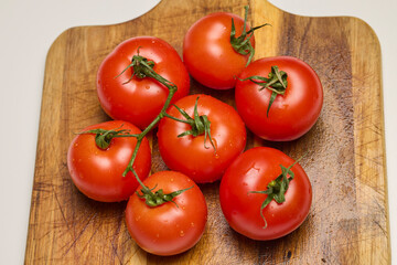 fresh tomatoes on a wooden chopping board