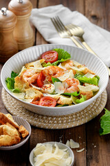 Classic Italian Caesar Salad with Shrimp on wooden background