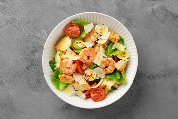 Classic Italian Caesar Salad with Shrimp. Gray background, top view