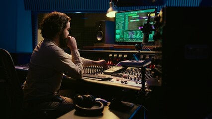 Music producer fixing coiled cable inside amplifier or audio compressor, prepares control room...