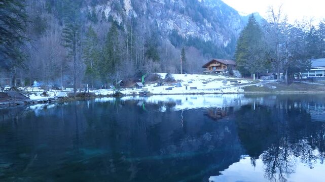 A view in wintertime of the Blue lake "Blausee" in the morning. Blausee Natural Park, Kandergrund, Switzerland. February 9, 2025.