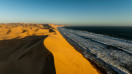 Aerial drone view of the ocean shore beaches next to the Namib dunes on a beautiful day of...