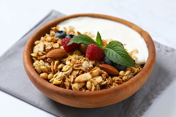 Delicious granola with berries and yogurt on a light background