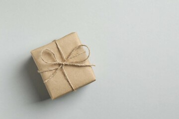 Beautiful gift box tied with bow on gray background 