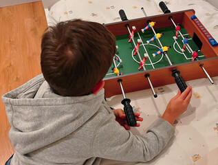 Niño feliz estrenando de regalo un juguete de futbolín el día de su cumpleaños