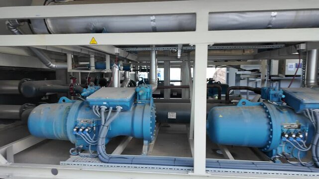 Industrial compressors inside a mechanical facility. Industrial air compressor systems with equipment machinary