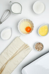 Baking Crinkle Cake. Near baking dish with ingredients, phyllo dough, egg, butter, nuts, milk