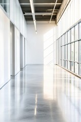 Obraz premium Interior design of a modern hallway featuring large windows, natural light, and polished concrete floors, ideal for architectural, real estate, or office space concepts.