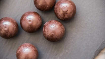 Obraz premium Zarte Schokokugeln in sanftem Licht und dunkler Umgebung