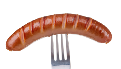 A close-up of a grilled sausage on a fork, highlighting its appetizing texture.