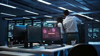 Team of technicians in server hub alerted by hacker passing firewall and stealing sensitive data. Coworkers panicking after seeing security breach notification on PC in data center workspace, camera B