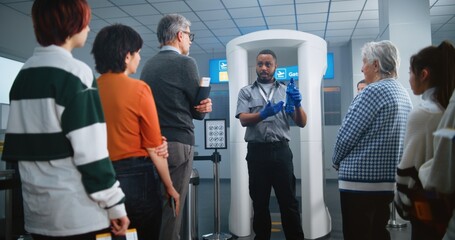 Airport Security Checkpoint: African American Security Officer Gives Instructions to Diverse...