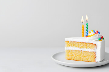 Appetizing piece of birthday cake on a plate with one burning candle  isolated on white background