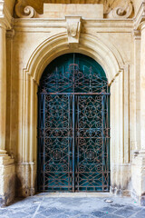 Fototapeta premium Ornate Iron Gate of a Historic Arched Entrance on Stone Structure