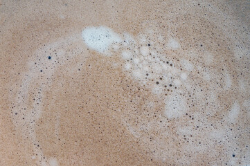 Coffee cream texture of fragrant coffee in a cup with delightful coffee colored bubbles with foam. macro coffee crema